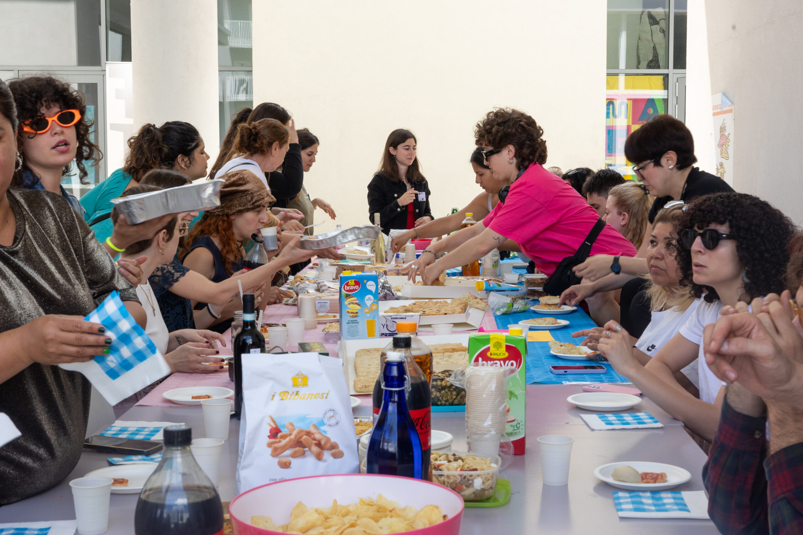 Il gruppo di circa trenta giovani della Direzione Artistica Partecipata Under 30 pranza intorno a una tavola imbandita.