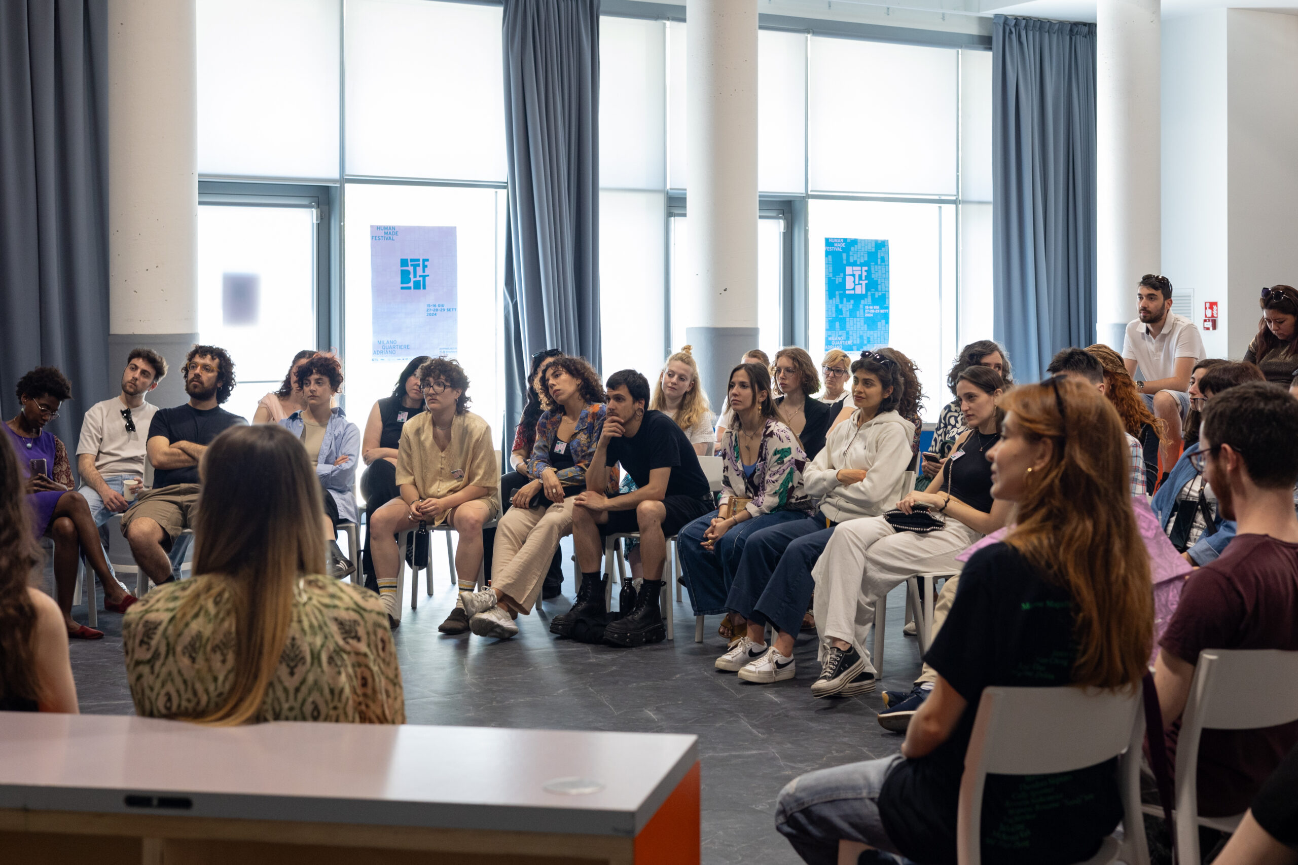 Pubblico variegato seduto in cerchio partecipa al laboratorio “Esercizi di immaginazione collettiva.