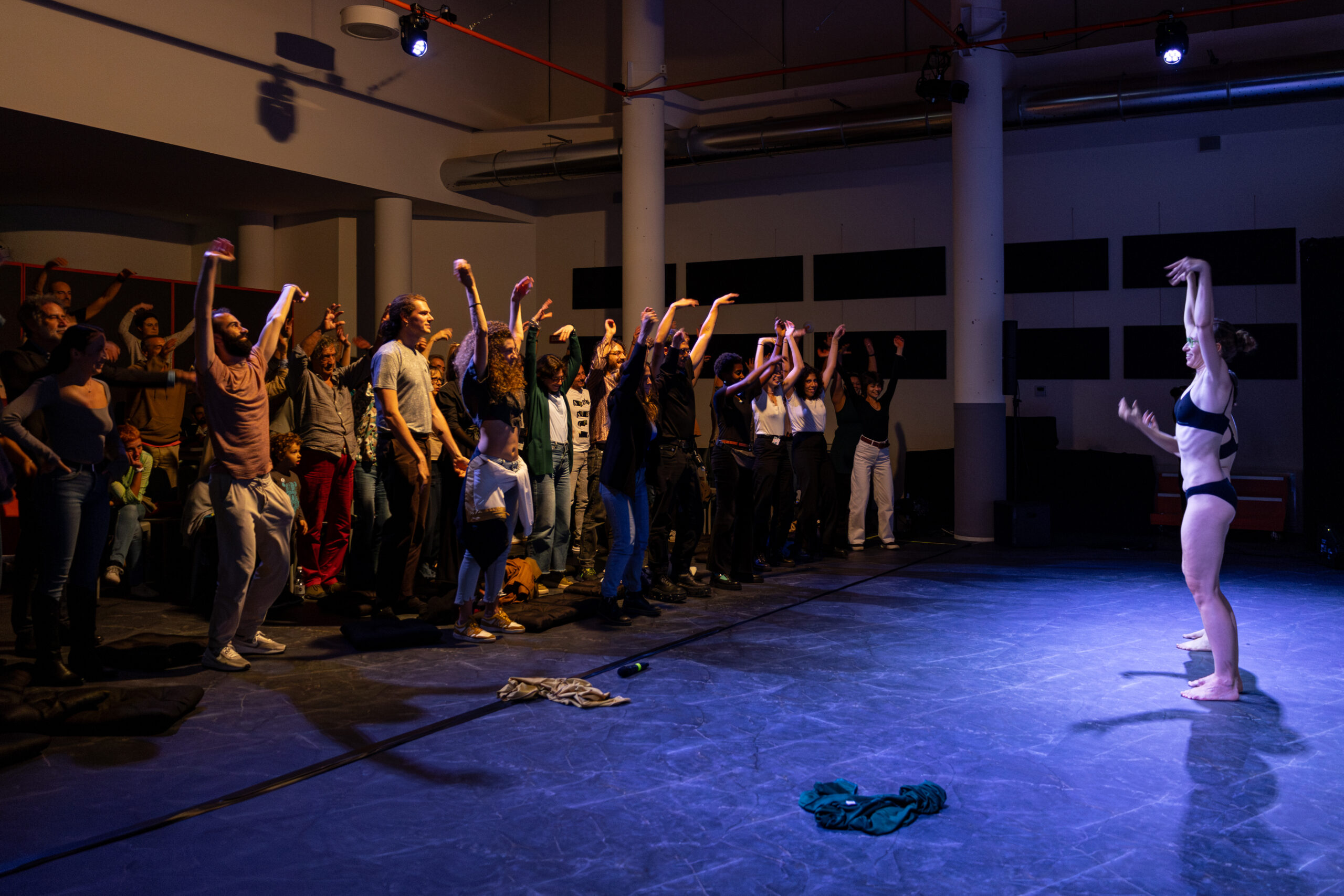 Durante la performance “Insectum” in Quartiere Adriano, le due performer in intimo alzano le braccia e fanno vibrare le mani di fronte al numeroso pubblico che le imita.