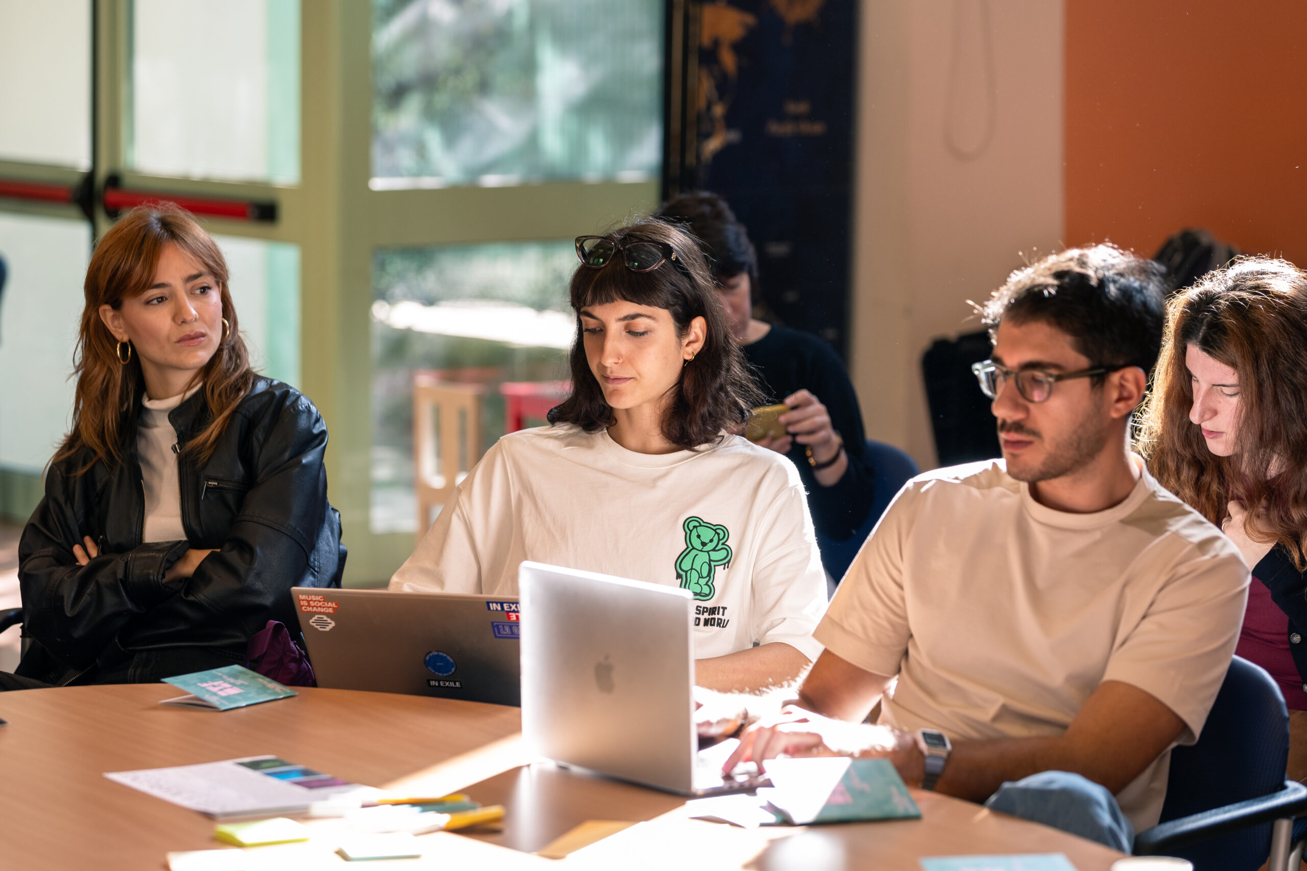 Due ragazze e un ragazzo, partecipanti del convegno “InVisible”, prendono appunti sui loro pc.