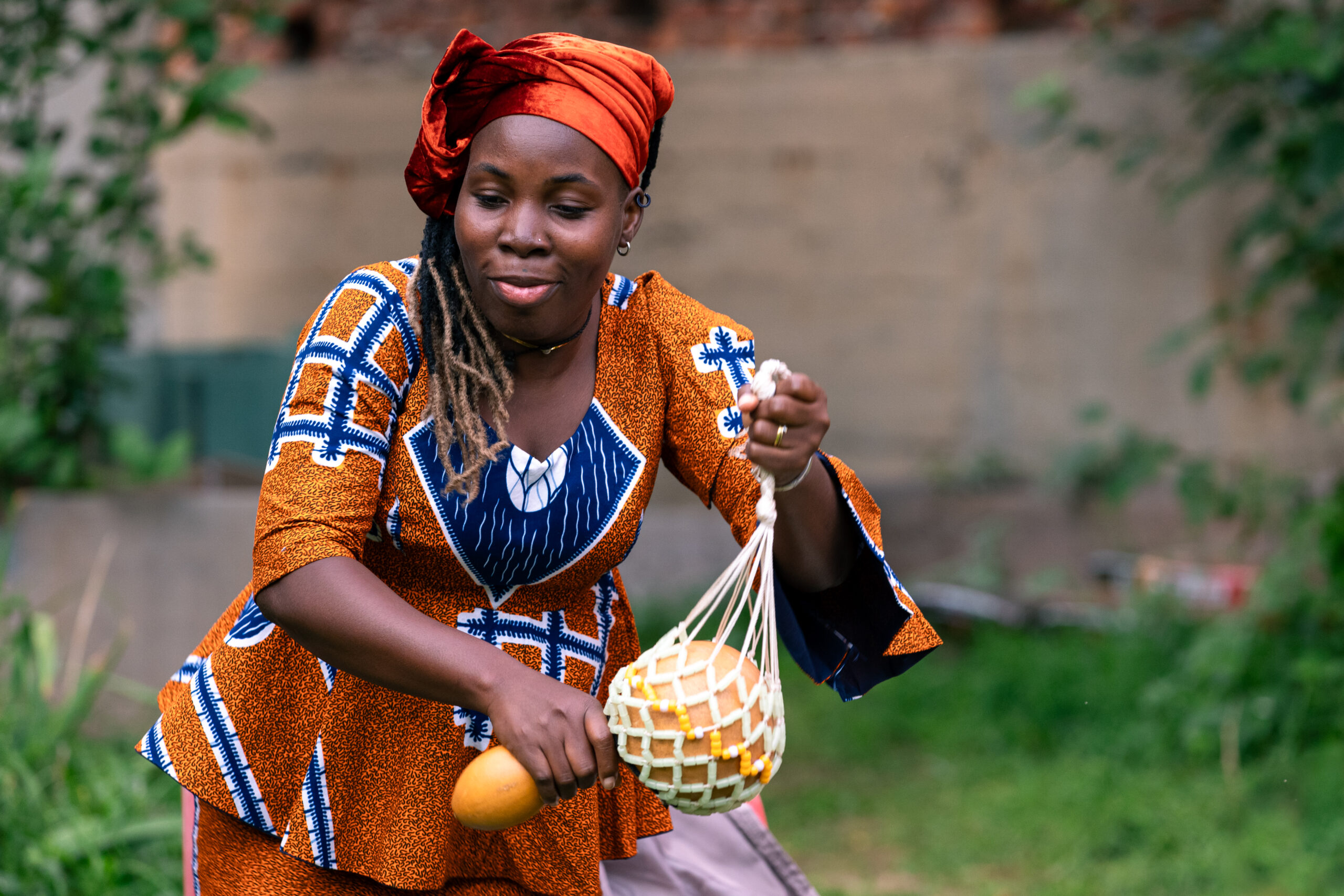 La performer africana dello spettacolo “Yele” in abito tradizionale suona uno strumento tipico.