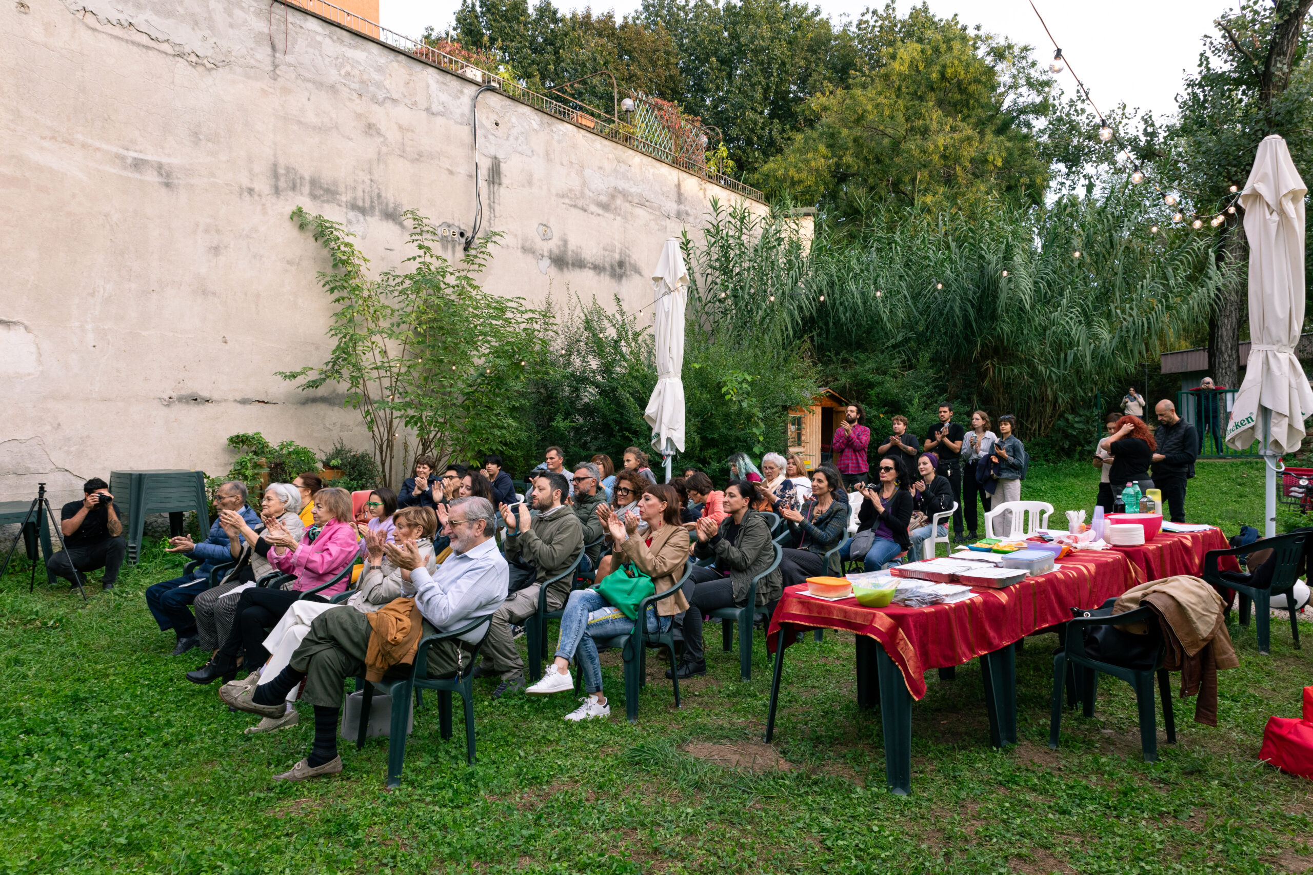 Durante lo spettacolo "Yele", il pubblico seduto all’aperto in un giardino cittadino applaude lo spettacolo a cui sta assistendo.
