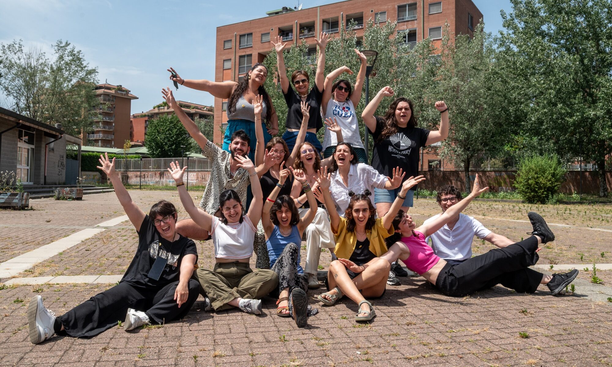 Un gruppo di persone, lo staff di BTTF Festival 2025, ride sullo sfondo urbano di Quartiere Adriano